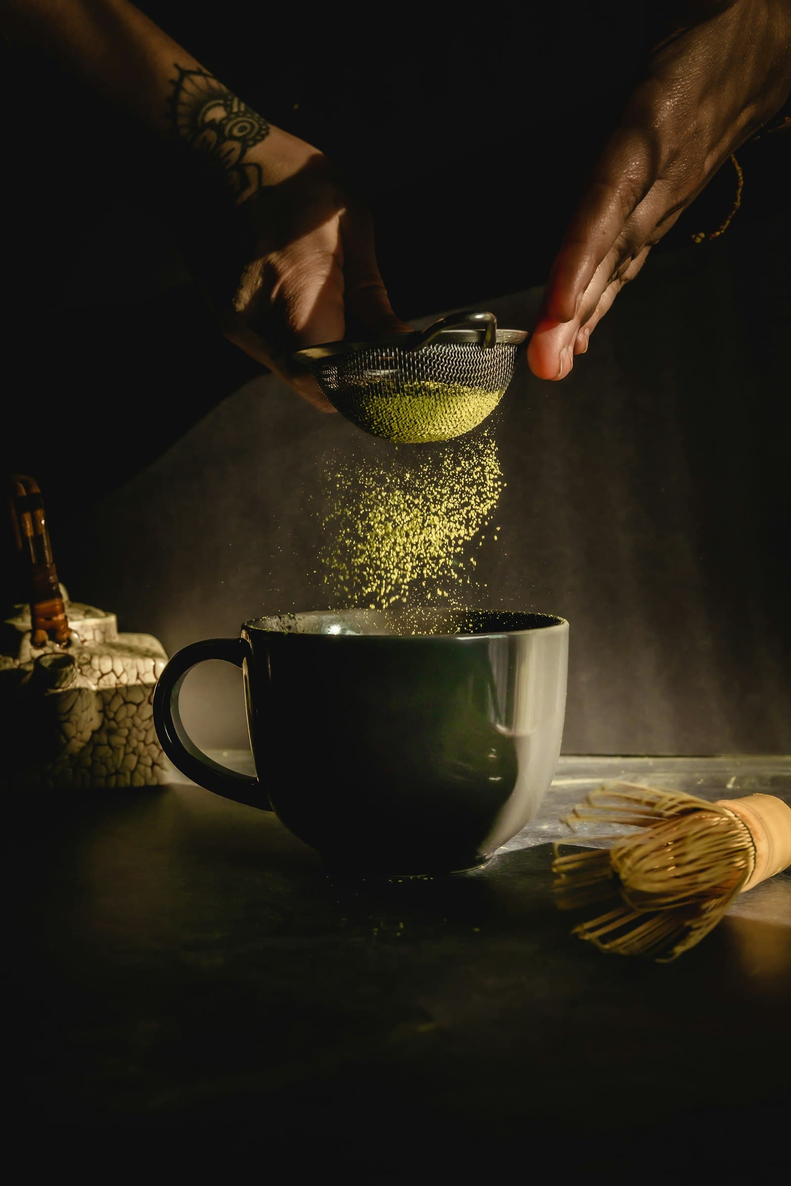 Matcha powder sifted into a dark mug